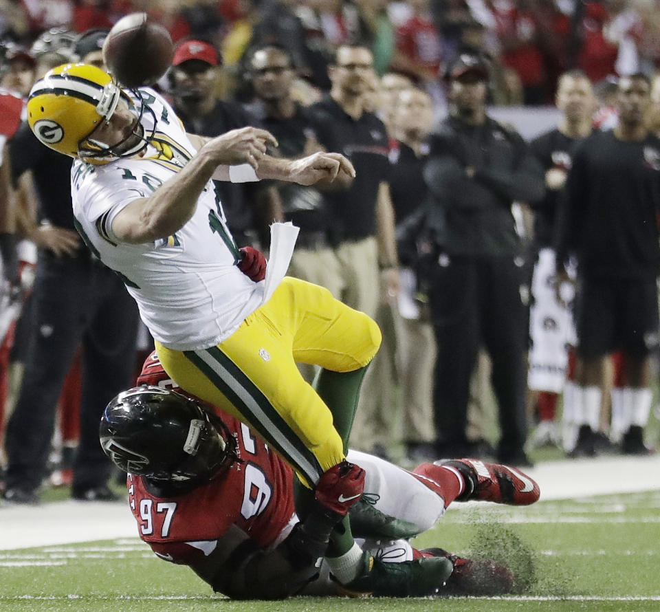 Green Bay Packers' Aaron Rodgers throws while in the grasp of Atlanta Falcons' Grady Jarrett during the second half of the NFL football NFC championship game, Sunday, Jan. 22, 2017, in Atlanta. (AP Photo/David Goldman)
