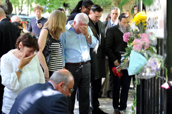 Mourners gather in front of her home