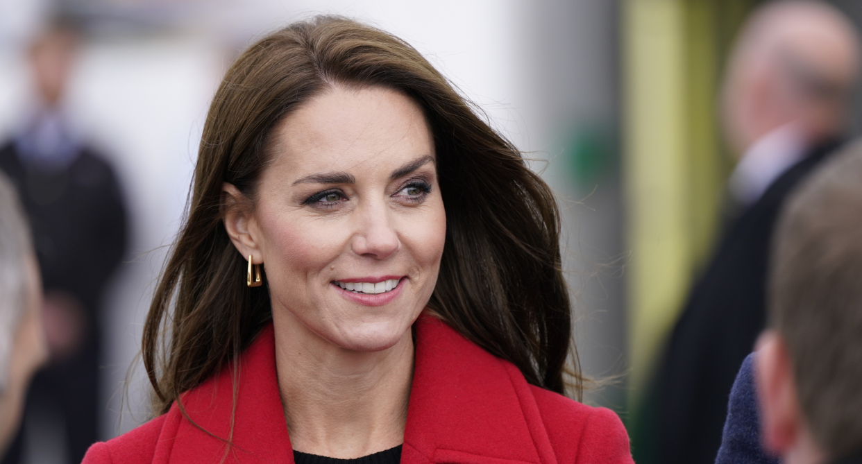 close up of kate middleton wearing gold earrings and a red coat, Kate Middleton just wore an elegant L.K.Bennett coat in her first official visit as the Princess of Wales (Photo via Getty)