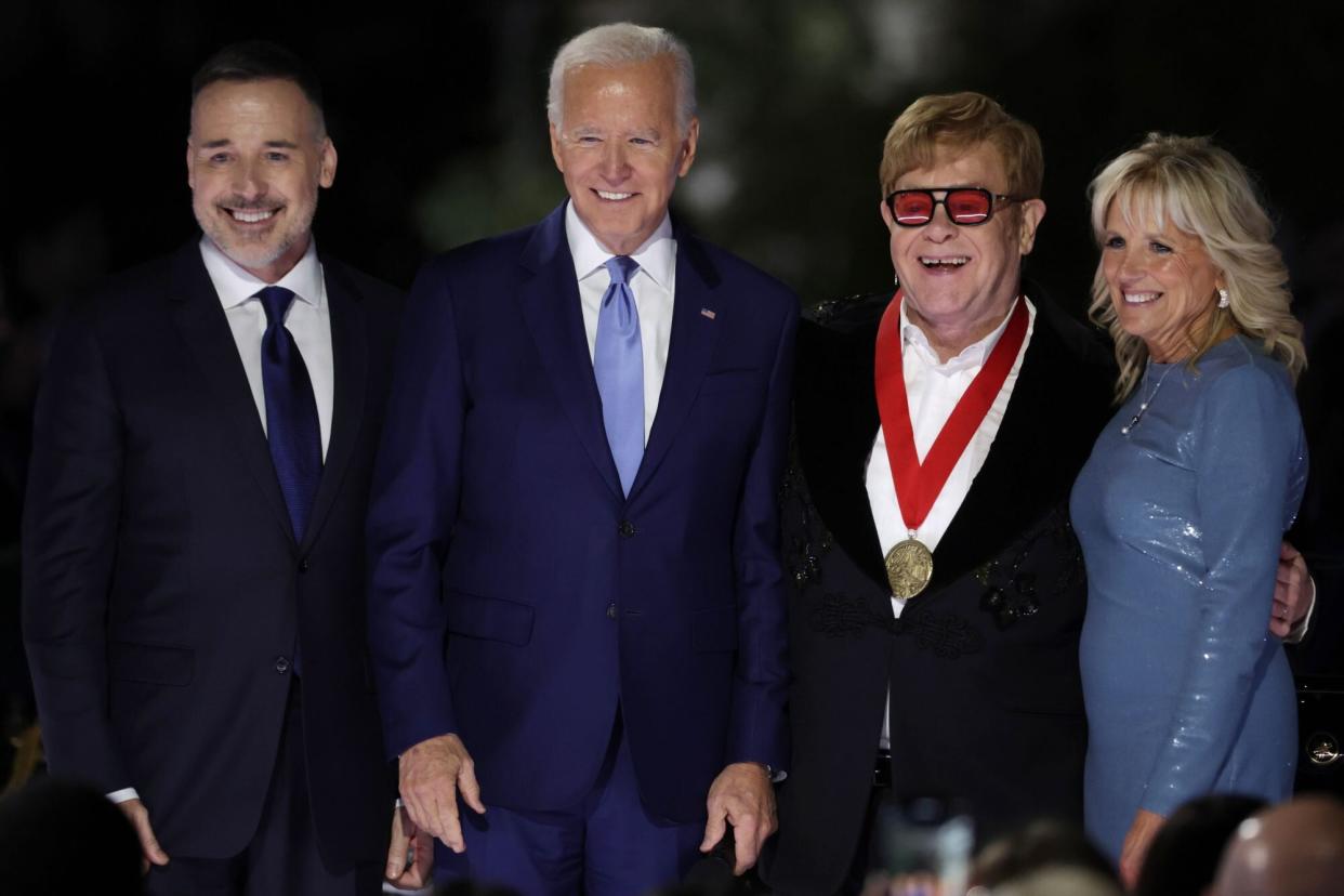 WASHINGTON, DC - SEPTEMBER 23: British singer-songwriter Sir Elton John (3rd L) poses for photos with his husband David Furnish (L), U.S. President Joe Biden (2nd L) and first lady Jill Biden (R) after he was presented with the National Humanities Medal during an event at the South Lawn of the White House on September 23, 2022 in Washington, DC. President Joe Biden and first lady Jill Biden hosted the event titled “A Night When Hope and History Rhyme,” to “celebrate the unifying and healing power of music, commend the life and work of Sir Elton John, and honor the everyday history-makers in the audience, including teachers, nurses, frontline workers, mental health advocates, students, LGBTQ+ advocates and more.” (Photo by Alex Wong/Getty Images)