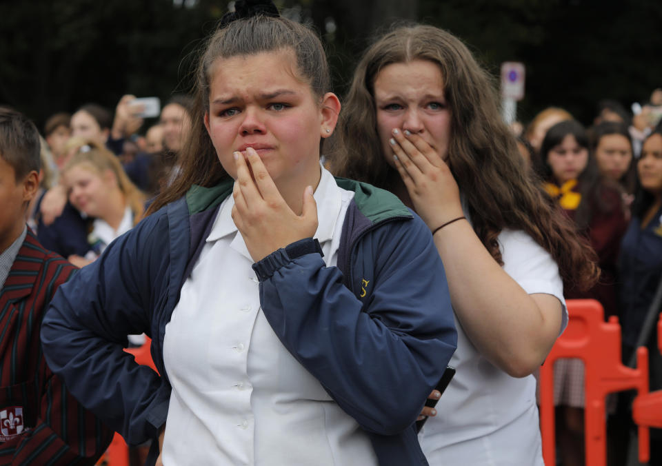 FILE - In this March 18, 2019, file photo, students react as they gather for a vigil to commemorate victims of a shooting, outside the Al Noor mosque in Christchurch, New Zealand. On March 15, 2019, a gunman allegedly fueled by anti-Muslim hatred attacked two mosques in Christchurch, killing 51 people. (AP Photo/Vincent Yu, File)