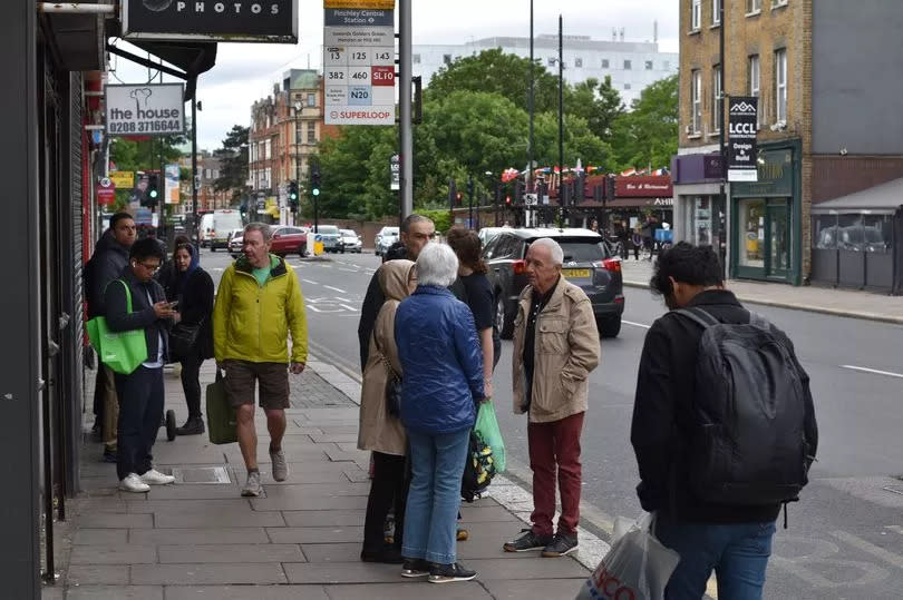 People at a bus stop in Finchley