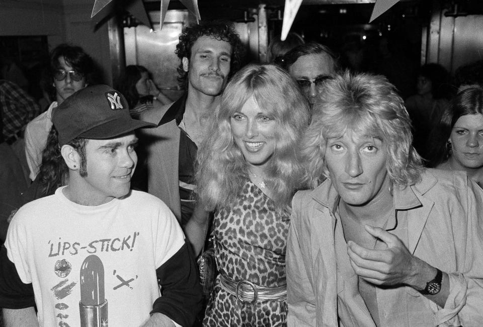 British pop singer Elton John, left, Lana Hamilton, wife of actor George Hamilton, and rock singer Rod Stewart arrive at New York's Studio 54, July 10, 1978, to celebrate at a party given by RCA Records, who signed John to a contract with the recording company.  Others are unidentified.  (AP Photo/G. Paul Burnett)