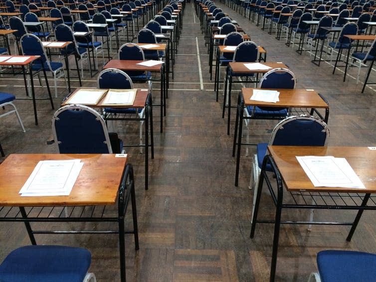 <span class="caption">This year, A-levels and GCSEs will not be decided by exams.</span> <span class="attribution"><a class="link " href="https://www.shutterstock.com/image-photo/empty-exam-hall-chair-desk-paper-744395434" rel="nofollow noopener" target="_blank" data-ylk="slk:fairuz othman/Shutterstock;elm:context_link;itc:0;sec:content-canvas">fairuz othman/Shutterstock</a></span>