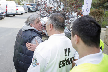 Romania's head coach Ilie Nastase is escorted by stewards outside the arena where the FedCup Group II play-off match between Romania and Great Britain takes place, in Constanta county, Romania, April 22, 2017. Inquam Photos/George Calin/via REUTERS