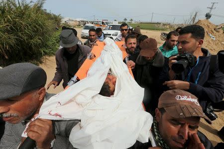 Mourners carry the body of 10-year-old Palestinian boy Yassin Abu Khoussa, whom medical officials said was killed by fragments from a missile fired by an Israeli aircraft, during his funeral in the northern Gaza Strip March 12, 2016. REUTERS/Mohammed Salem