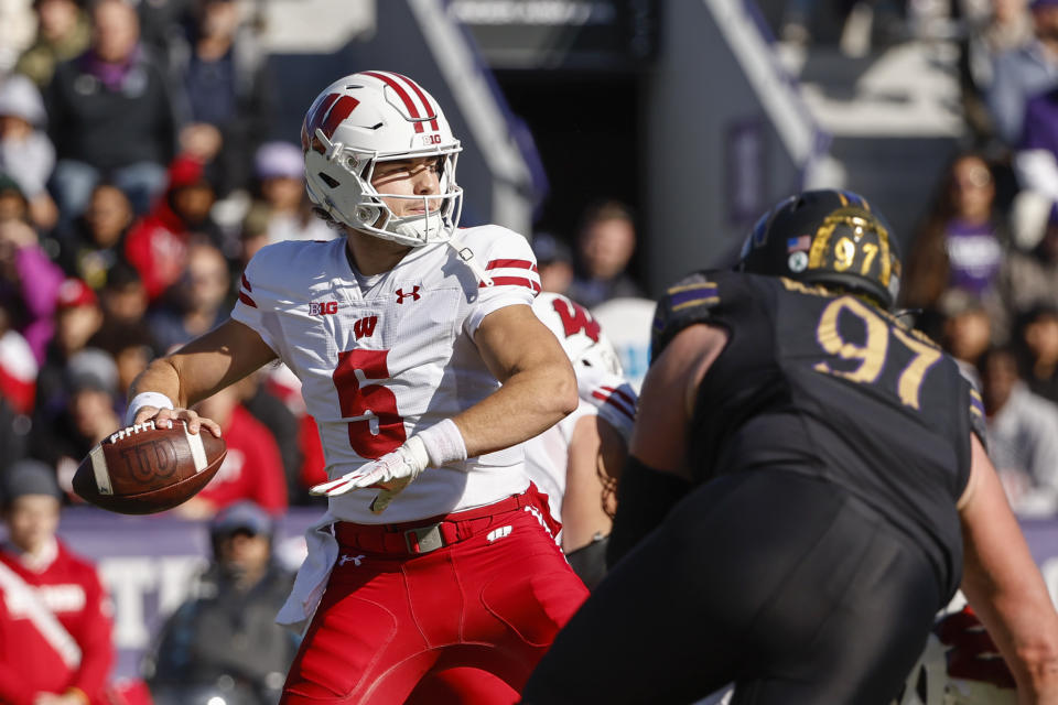 Wisconsin quarterback Graham Mertz (5) looks to pass the ball against Northwestern defensive lineman Sean McLaughlin (97) during the first half of an NCAA college football game on Saturday, Oct. 8, 2022, in Evanston, Ill. (AP Photo/Kamil Krzaczynski)