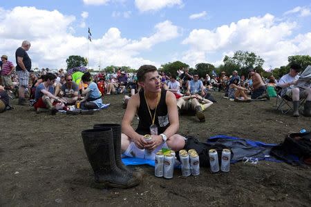 A festival goer waits for the music to begin on the Pyramid stage at Worthy Farm in Somerset, during the Glastonbury Festival June 29, 2014. REUTERS/Cathal McNaughton