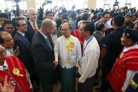 Myanmar's President Thein Sein (C, with yellow ribbon) greets international witnesses after the signing ceremony of the Nationwide Ceasefire Agreement (NCA) in Naypyitaw, Myanmar October 15, 2015. REUTERS/Soe Zeya Tun