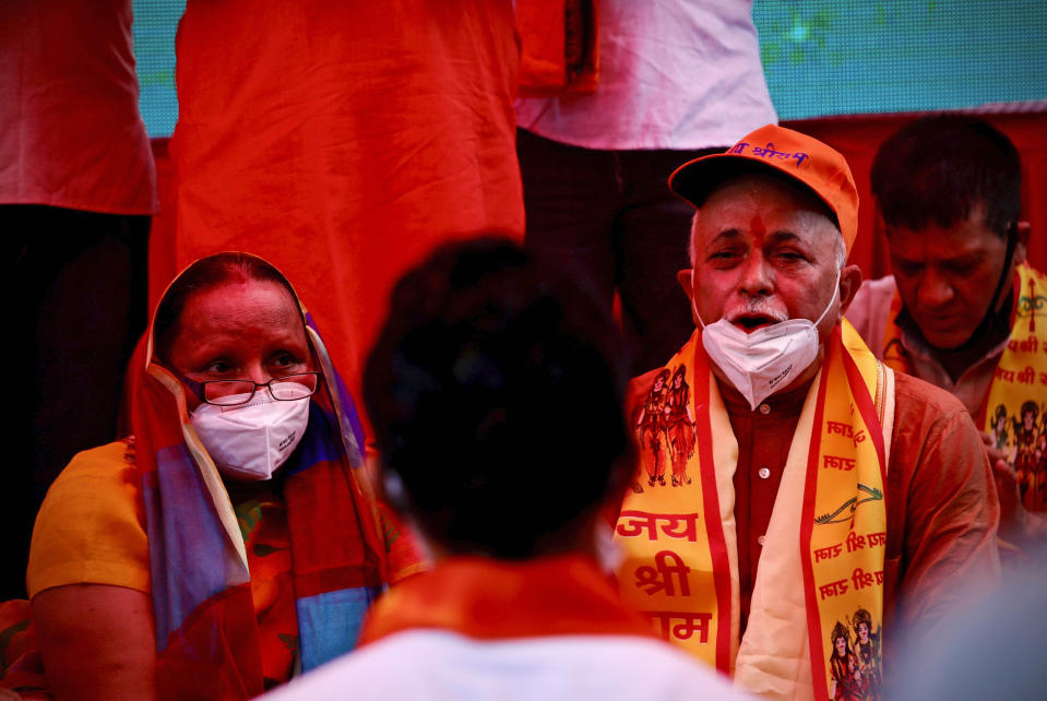 Hindus offer prayers for a groundbreaking ceremony of a temple dedicated to the Hindu god Ram in Ayodhya, at the Vishwa Hindu Parishad, or World Hindu Council, headquarters in New Delhi, India, Wednesday, Aug. 5, 2020. The coronavirus is restricting a large crowd, but Hindus were joyful before Prime Minister Narendra Modi breaks ground Wednesday on a long-awaited temple of their most revered god Ram at the site of a demolished 16th century mosque in northern India. (AP Photo/Manish Swarup)