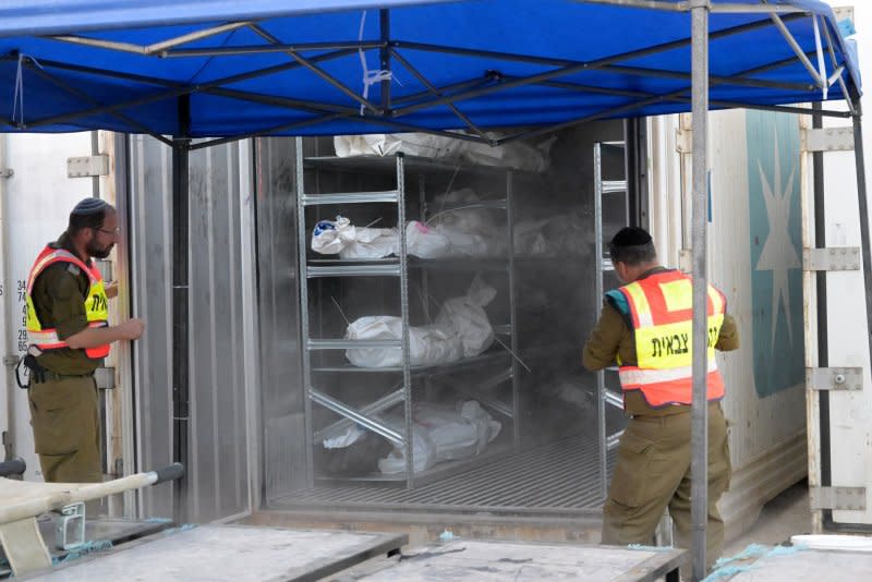 Soldiers from the military rabbinate unit open containers full of bodies and body parts of people murdered by Hamas near the Gaza border, at the military morgue on the Shura Army Base near Ramla, on Tuesday. The process of identifying the dead is complicated by the extreme mutilation and severely burned bodies. Photo by Debbie Hill/UPI