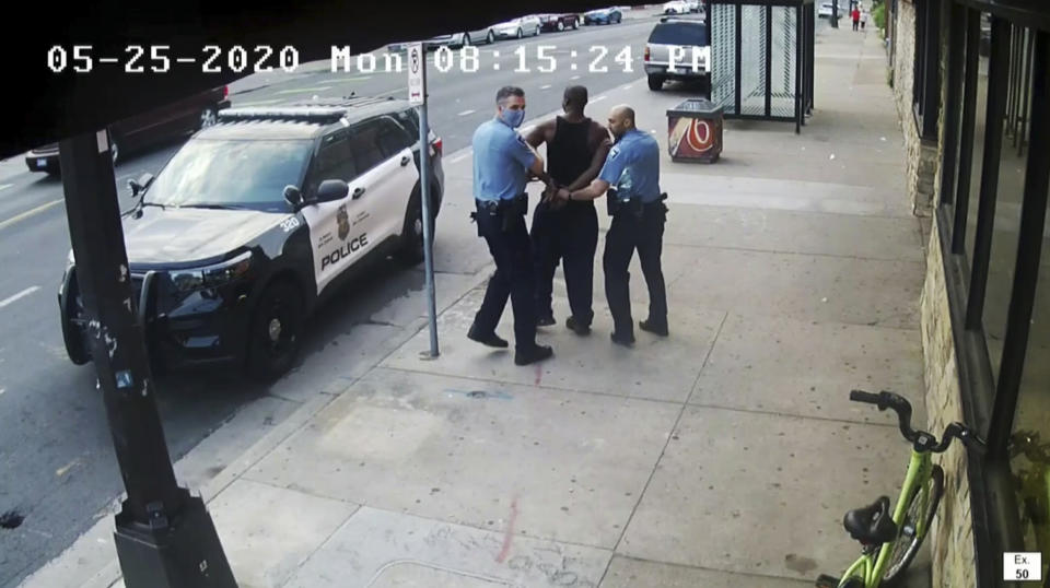 FILE - This image from surveillance video introduced into evidence during court shows Minneapolis police Officers Thomas Lane, left and J. Alexander Kueng, right, escorting George Floyd, center, to a police vehicle outside Cup Foods in Minneapolis, on May 25, 2020. Former police officers Tou Thao, Kueng and Lane are on trial in federal court accused of violating Floyd's civil rights as fellow Officer Derek Chauvin killed him. (Surveillance Video/State of Minnesota via AP, File)