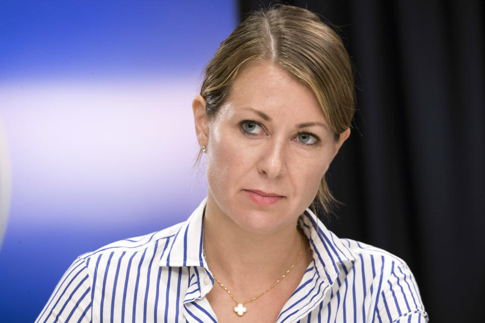 FILE— In this Sept. 14, 2018 file photo, Secretary to the Governor Melissa DeRosa listens as New York Gov. Andrew Cuomo speaks to reporters during a news conference, in New York. De Rosa, Cuomo's top aide, told top Democrats frustrated with the administration's long-delayed release of data about nursing home deaths that the administration "froze" over worries about what information was "going to be used against us," according to a Democratic lawmaker who attended the Wednesday, Feb. 10, 2021 meeting and a partial transcript provided by the governor's office. (AP Photo/Mary Altaffer, File)