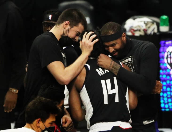 LOS ANGELES, CA - JUNE 18, 2021: Teammates hug high-scorer LA Clippers guard Terance Mann (14) during a timeout as the Clippers beat the Utah Jazz to advance to the Western Conference NBA Playoffs at Staples Center on June 18, 2021 in Los Angeles, California.(Gina Ferazzi / Los Angeles Times)