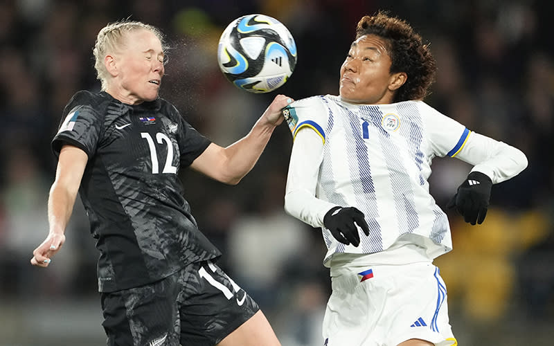 Two soccer players from opposing teams compete to head the ball during the Women's World Cup Group A soccer match. The ball is suspended in the air between the two.