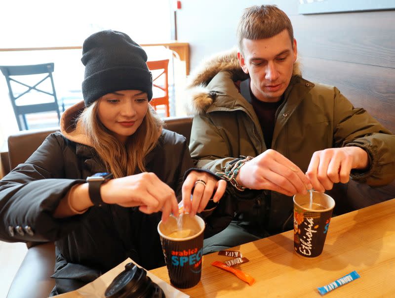 FILE PHOTO: Alexandr Kudlay and Viktoria Pustovitova drink coffee in a cafe in Kharkiv