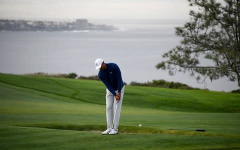 Tiger Woods hits his second shot on the fourth hole during the pro-am round of the Farmer's Insurance - Credit: AP