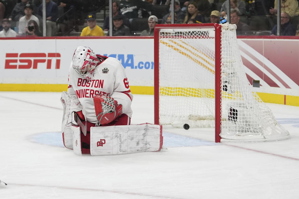 Boston University goaltender Mathieu Caron gives up a goal during overtime of a semifinal game against Denver at the Frozen Four NCAA college hockey tournament Thursday, April 11, 2024, in St. Paul, Minn. (AP Photo/Abbie Parr)