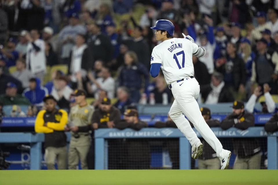 Los Angeles Dodgers' Shohei Ohtani gestures as he heads to first after hitting a solo home run.