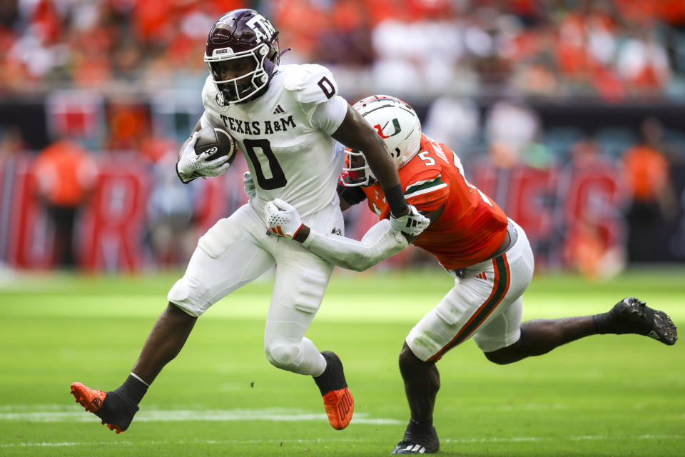 Sep 9, 2023; Miami Gardens, Florida; Texas A&M Aggies wide receiver Ainias Smith (0) runs with the ball ahead of Miami Hurricanes safety Kamren Kinchens (5) during the first quarter at Hard Rock Stadium. Sam Navarro-USA TODAY Sports