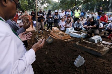 An Islamic cleric (L) holds a prayer for Indonesian death row prisoner Zaenal Abidin during his funeral in Cilacap, Central Java, Indonesia, April 29, 2015. REUTERS/Beawiharta