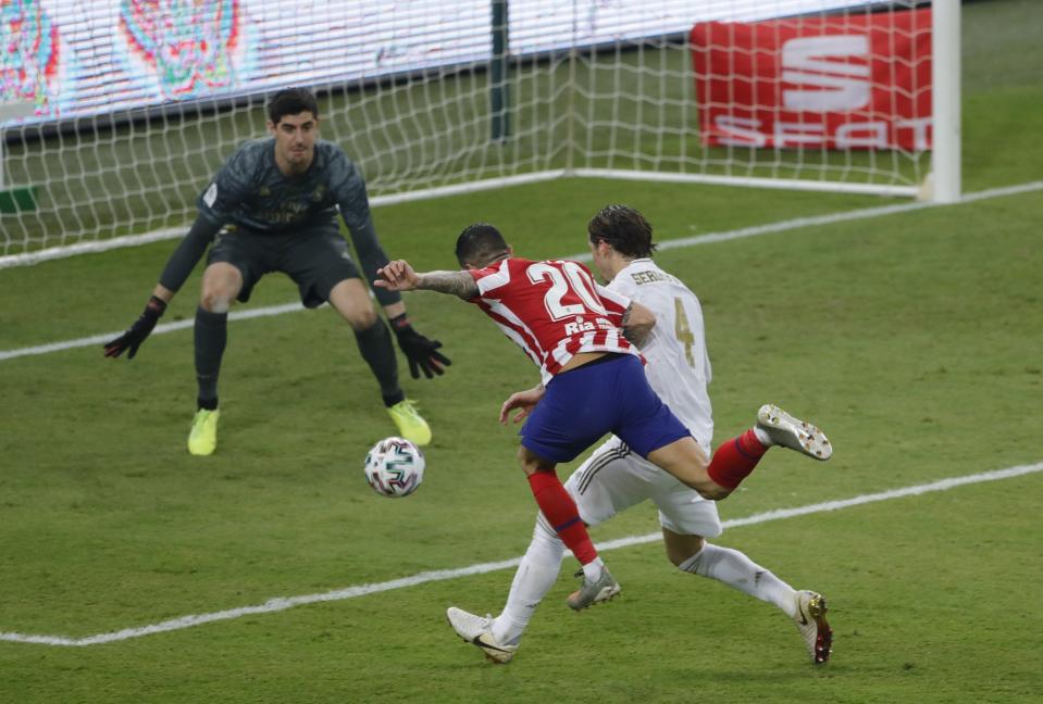 Atletico Madrid's Vitolo shoots the ball as Real Madrid's Sergio Ramos tries to stop him during the Spanish Super Cup Final soccer match between Real Madrid and Atletico Madrid at King Abdullah stadium in Jiddah, Saudi Arabia, Monday, Jan. 13, 2020. (AP Photo/Amr Nabil)