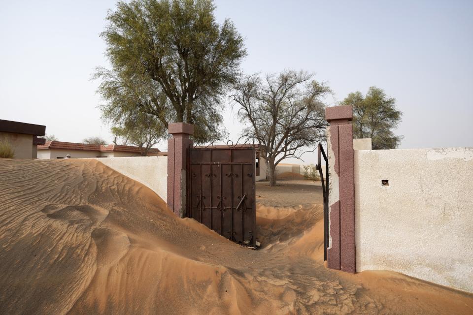A house's entrance gate is buried under the sand at the Bedouin village of al-Ghuraifabout 100 km, 62 miles, southeast of Sharjah, United Arab Emirates, Sunday, July 9, 2023. Built-in the 1970s, the village was abandoned two decades later as oil wealth transformed the country into a global hub of commerce and tourism, home to the futuristic cities of Dubai and Abu Dhabi. (AP Photo/Kamran Jebreili)