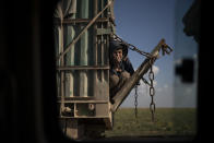 A boy rides in the back of a truck that is part of a convoy evacuating hundreds out of the last territory held by Islamic State militants, in Baghouz, eastern Syria, Wednesday, Feb. 20, 2019. The evacuation signals the end of a week long standoff and opens the way to U.S.-backed Syrian Democratic Forces (SDF) recapture the territory. (AP Photo/Felipe Dana)