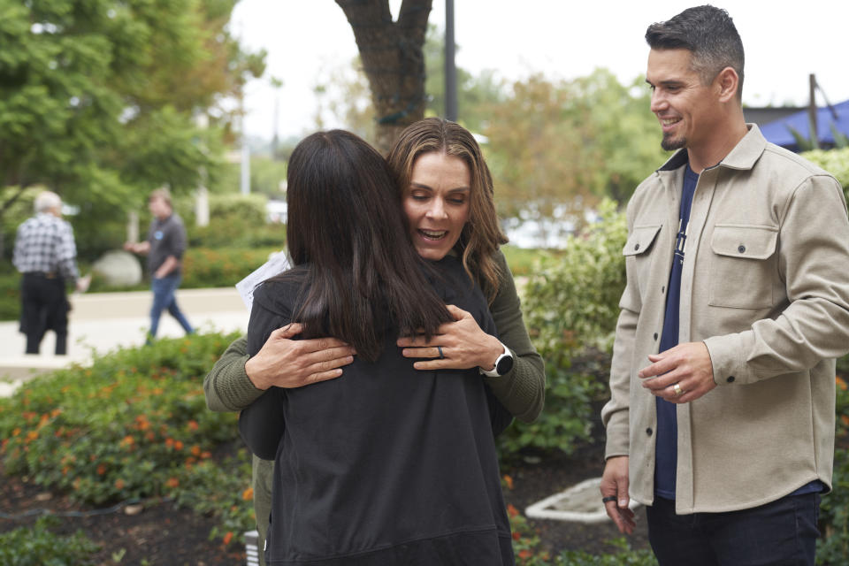 FILE - Stacie Wood, center, and her husband, Andy Wood, meet with a congregant after his sermon on Sunday, Oct. 16, 2022, at Saddleback Church in Lake Forest, Calif. Stacie Wood, the woman pastor at the center of the Southern Baptist Convention's decision to oust Saddleback Church, has said in February 2023, she will continue to serve as a ministry leader despite her longstanding ties to the nation's largest Protestant denomination. (AP Photo/Allison Dinner, File)