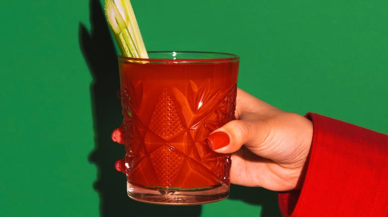 Female hand holding a Bloody Mary cocktail