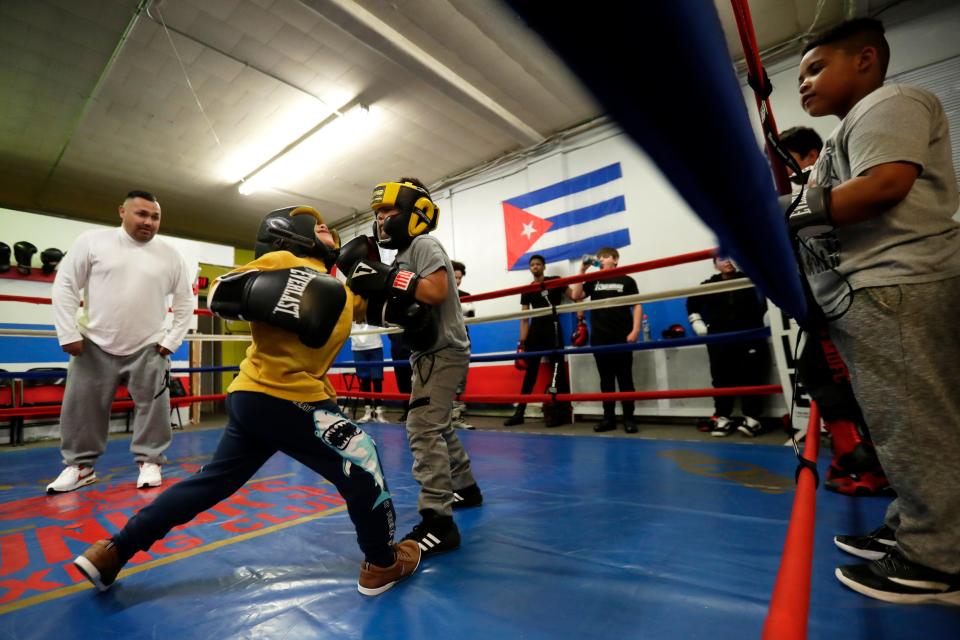 Junior's Boxing Club owner Javier Becerra, left, oversees a sparring match between two young boxers at his gym on March 31, 2022, in Green Bay.