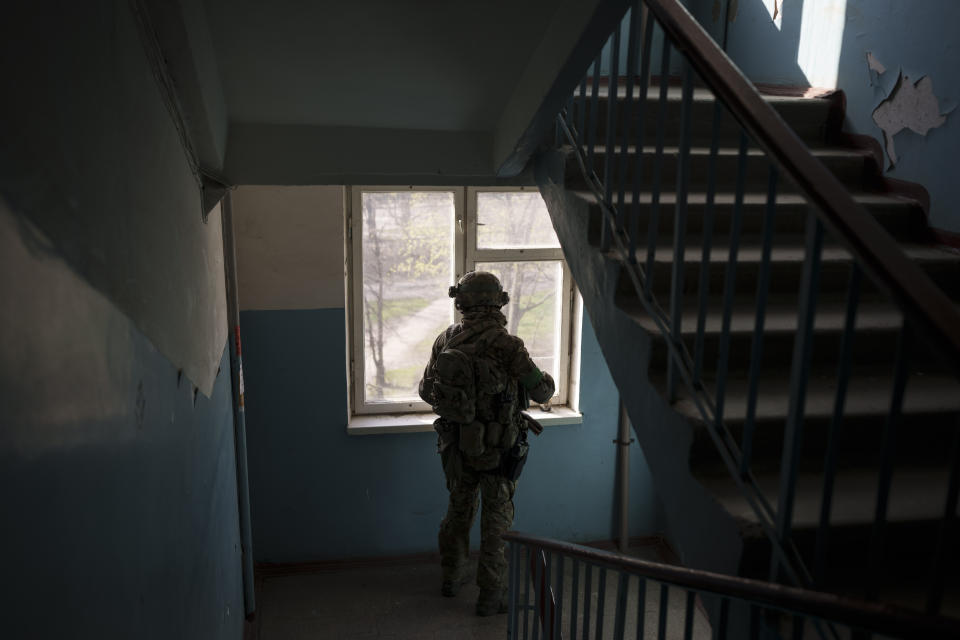 A Security Service of Ukraine (SBU) serviceman looks out of a building during an operation to arrest suspected Russian collaborators in Kharkiv, Ukraine, Thursday, April 14, 2022. Ukrainian authorities are cracking down on anyone suspected of aiding Russian troops under laws enacted by Ukraine’s parliament and signed by President Volodymyr Zelenskyy after the Feb. 24 invasion. Offenders face up to 15 years in prison for acts of collaborating with the invaders or showing public support for them. (AP Photo/Felipe Dana)