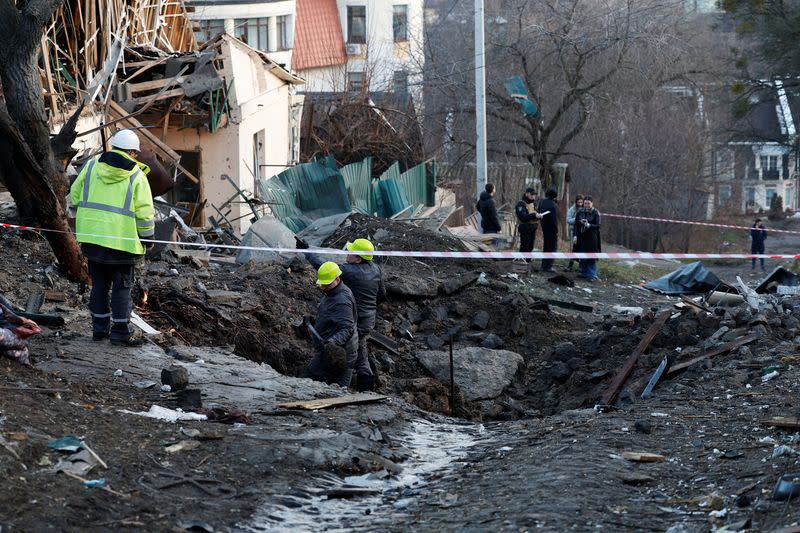 Personas trabajan en un sitio de un ataque con misiles rusos, en medio del ataque de Rusia a Ucrania, en Kiev, Ucrania