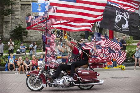 Spectators line the street as Harley riders participate during the the Harley Davidson 110th Anniversary Celebration parade in Wisconsin Avenue, Milwaukee August 31, 2013. REUTERS/Sara Stathas