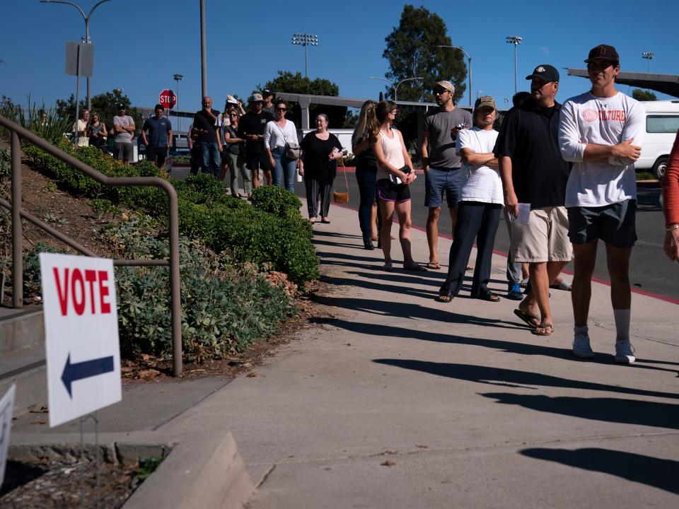 People wait in line outside a vote center to cast their ballots, Tuesday, Sept. 14, 2021, in Huntington Beach, Calif.