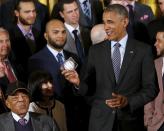 U.S. President Barack Obama (R) holds an autographed ball he was given as he plays host to a reception for the San Francisco Giants, Major League Baseball's 2014 World Series champions, in the East Room of the White House in Washington, June 4, 2015. Also pictured is Hall of Fame player Willie Mays (bottom L). REUTERS/Jonathan Ernst