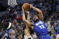 Minnesota Timberwolves center Karl-Anthony Towns (32) shoots on San Antonio Spurs guard Tre Jones (33) in the first quarter during an NBA basketball game Thursday, April 7, 2022, in Minneapolis.(AP Photo/Andy Clayton-King)