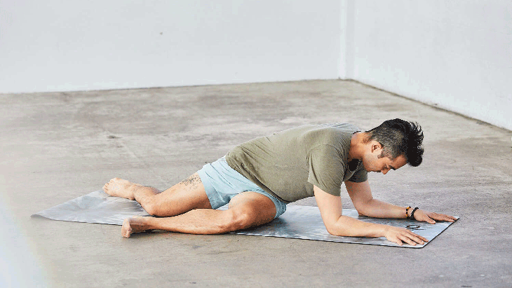 A moving image shows a person demonstrating lazy Pigeon Pose