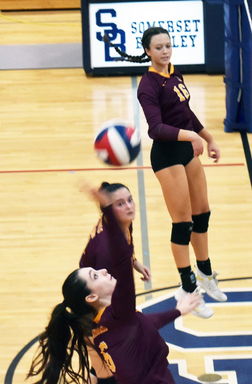 Case's Ava Silva, bottom, hits a shot over the net as Olivia Silva and Hannah Storm watch.