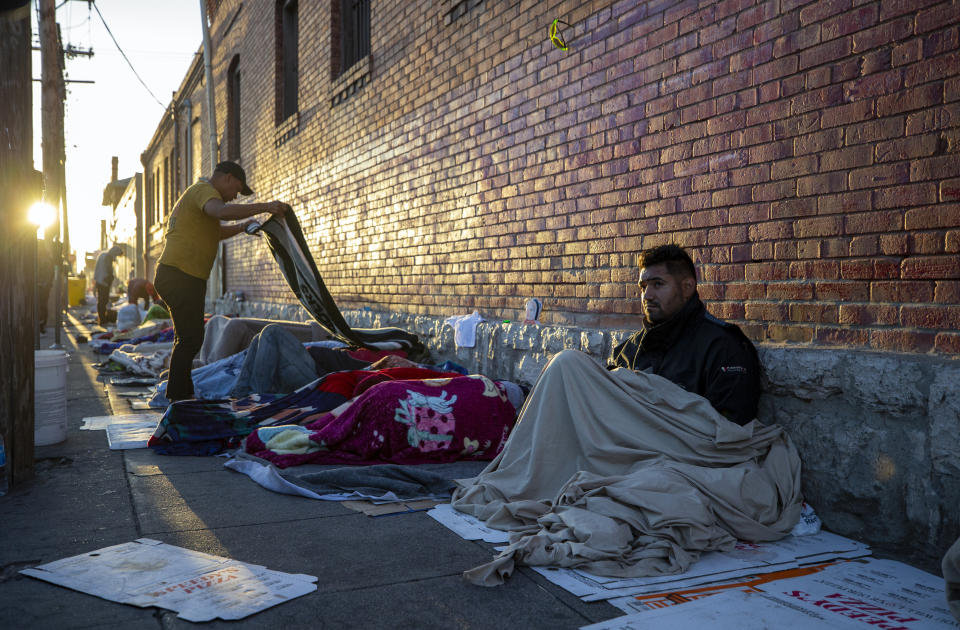 In this photo taken on Tuesday, May 9, 2023, migrants wake up at the campsite outside Sacred Heart Church in downtown El Paso, Texas. As confusion explodes in El Paso, one of the busiest illegal crossings points for migrants seeking to flee poverty and political strife, faith leaders continue to provide shelter, legal advice and prayer. (AP Photo/Andres Leighton)