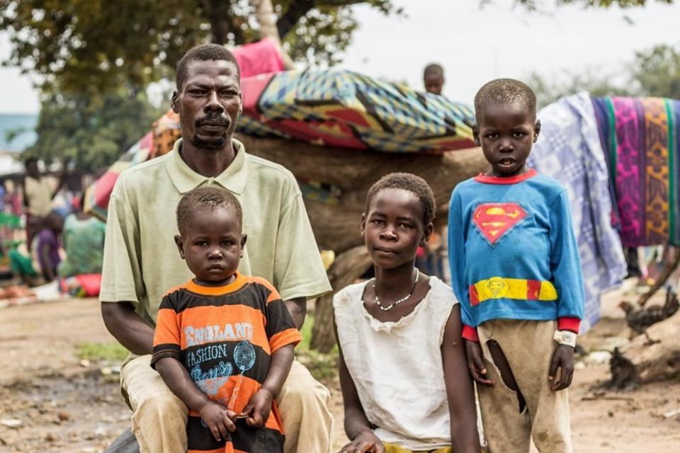 Michael T., 42, and his three children wait to be relocated from the Ocea Reception Centre to the Bidi Bidi refugee settlement. "I was in Juba with my family on July 7. At around 10 a.m., we heard gunshots. People got confused. Everyone started running around, looking for shelter. My wife and oldest son were caught in the middle of gunfire. I lost them. My wife and my son."&nbsp;<i>Location: Ocea Reception Centre, Nov. 4, 2016.</i>