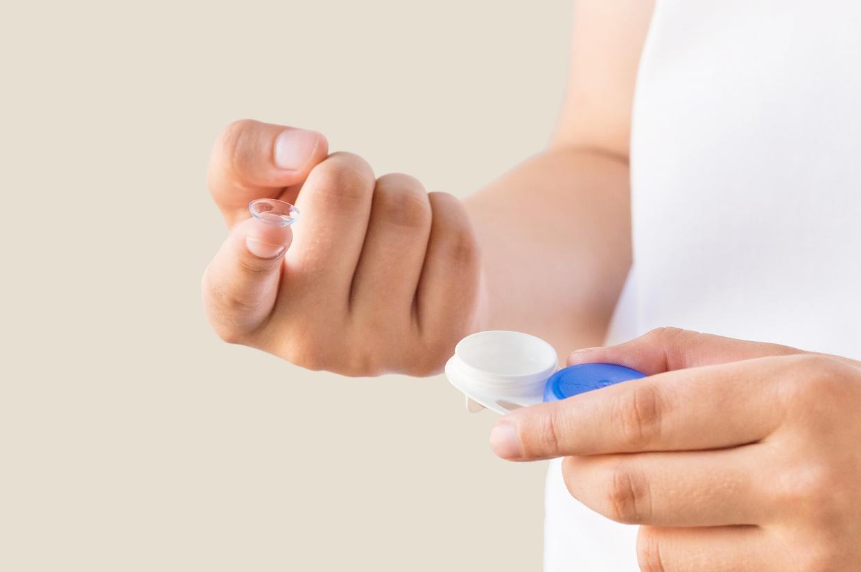 Woman with contact lens and case