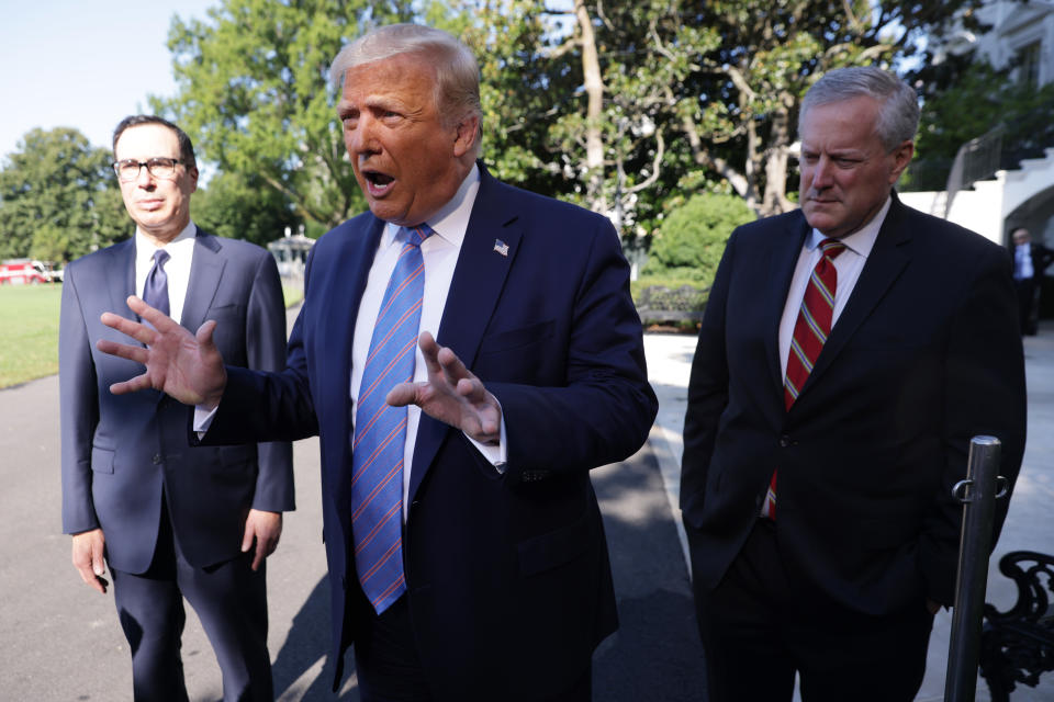 WASHINGTON, DC - JULY 29:  U.S. President Donald Trump speaks as Secretary of Treasury Steven Mnuchin (L) and White House Chief of Staff Mark Meadows (R) listen prior to Trump's Marine One departure from the South Lawn of the White House July 29, 2020 in Washington, DC. President Trump is traveling to visit the Double Eagle Energy oil rig in Midland, Texas, and will attend a fundraising luncheon for the Republican Party and his reelection campaign.  (Photo by Alex Wong/Getty Images)