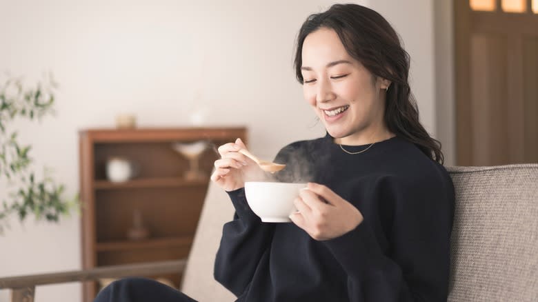 Asian woman eating clear soup