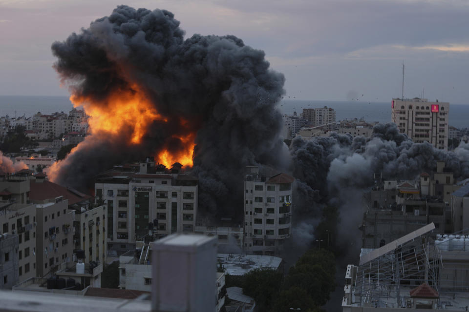 Fire and smoke rise from an explosion on a Palestinian apartment tower following an Israeli air strike in Gaza City, Saturday, Oct. 7, 2023.