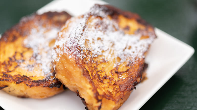 French toast with powdered sugar on white plate