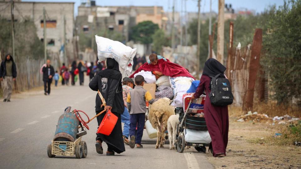 PHOTO: Displaced Palestinians in Rafah in the southern Gaza Strip carry their belongings as they leave following an evacuation order by the Israeli army, May 6, 2024. (AFP via Getty Images)