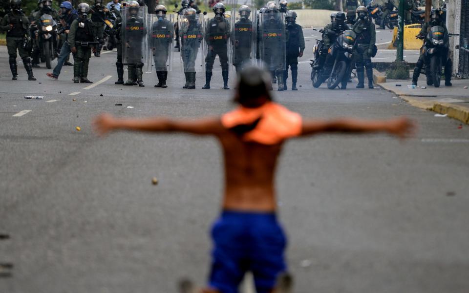 Opposition activists clash with riot police during a protest against President Nicolas Maduro in Caracas on April 26, 2017 - Credit: FEDERICO PARRA/AFP