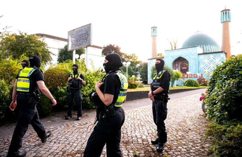 Police officers stand in front of the Islamic Center Hamburg with the Imam Ali Mosque (Blue Mosque) on the Outer Alster during a raid. Daniel Bockwoldt/dpa