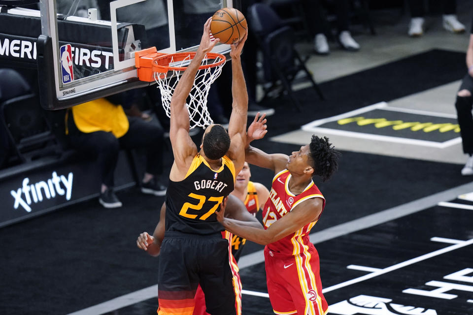 Utah Jazz center Rudy Gobert (27) dunks next to Atlanta Hawks forward De'Andre Hunter (12) during the first half of an NBA basketball game Friday, Jan. 15, 2021, in Salt Lake City. (AP Photo/Rick Bowmer)